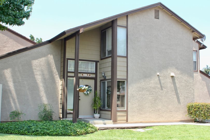 georgeous big beige house with garden and bushes in front with a view