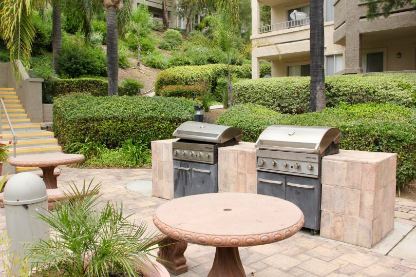 Two outdoor barbecue grills and seating on patio of Triana at Corona Ranch in Corona, CA.
