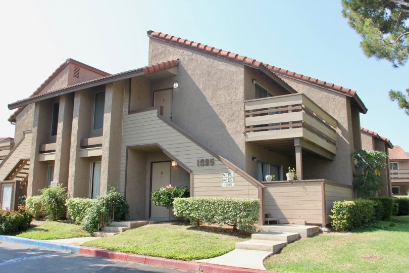 A slanted roof sits on top of a taupe like gray building at the Windwood Condos.