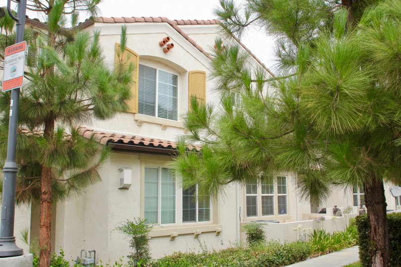 Trees are front of a house with two floors in Aspen Hills community