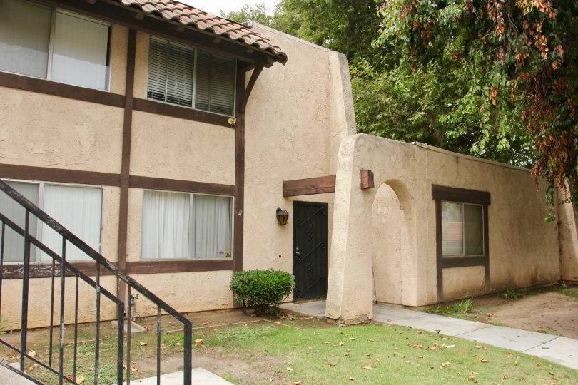 Spanish Pueblo looking architecture with shady grass and large trees