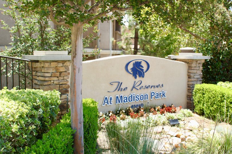 Stones and flowers sit in front of a sign at the Reserves at Madison park.