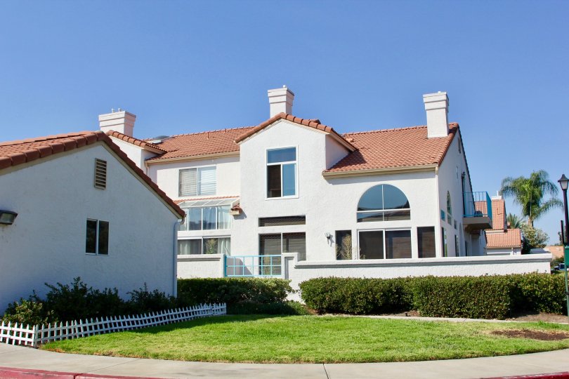 White condos view with manicured lawn and beautiful blue sky