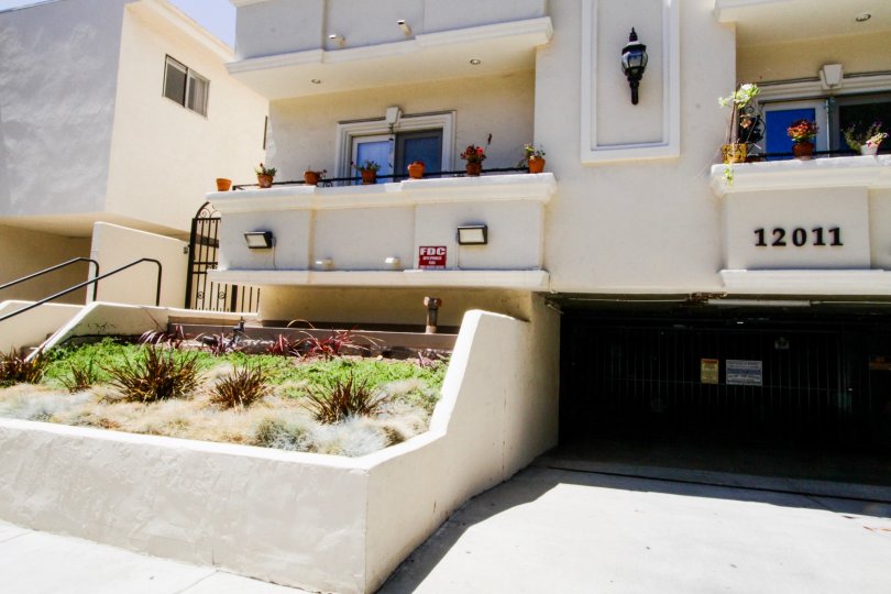 Raised planters filled with greenery in front of Del Cielo Condos