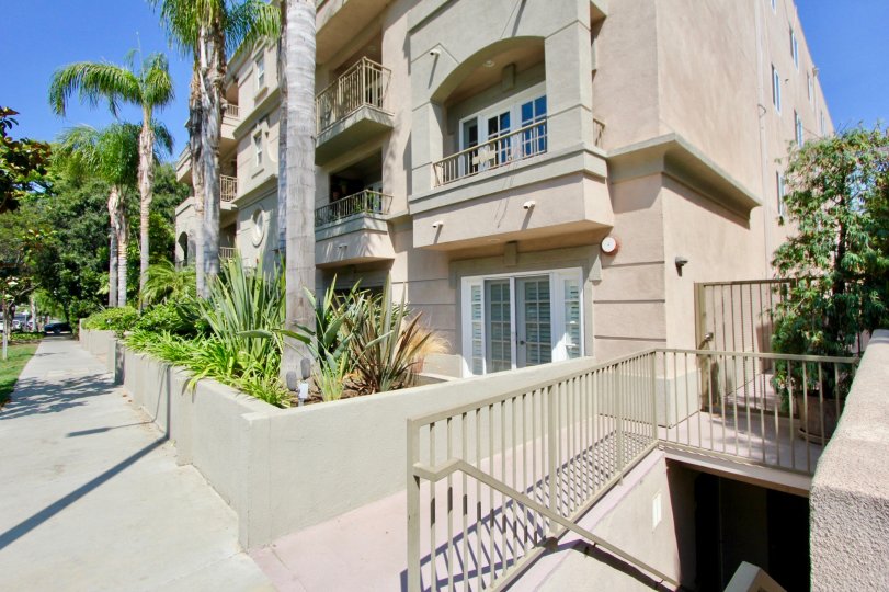 A tan building in the Brentwood Darlington community with palm trees and a balcony