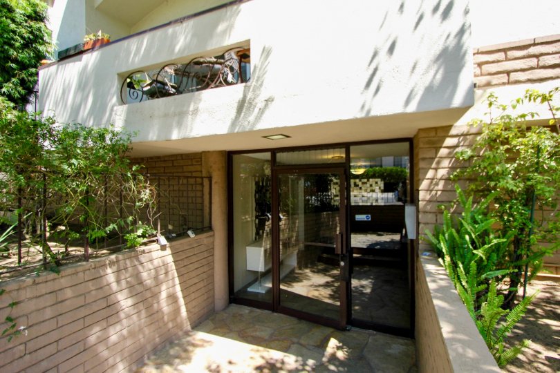Mayfield Plaza glass door entrance with stone walkway and brick walls and landscaping