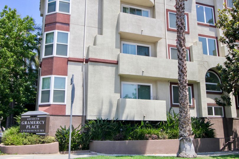 A APARTMENT WITH THREE FLOORS AND GLASS WINDOW SOME TREES ALSO NEAR TO THE PLACE AT THE MORNING TIME
