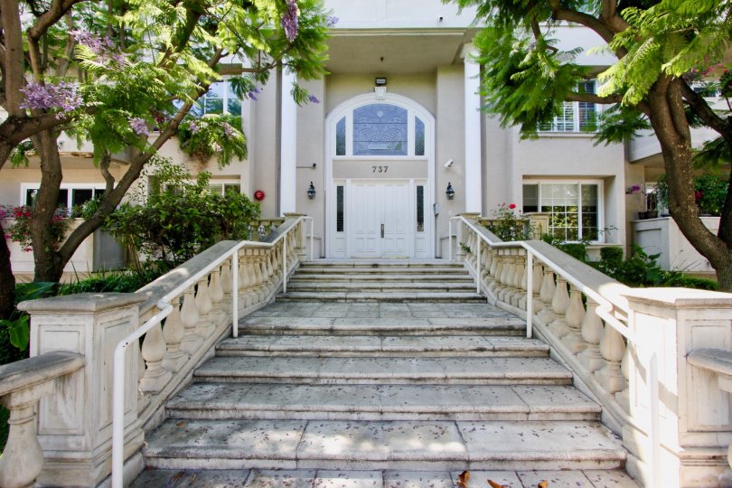 Seed ladders with very ornate baroque style railings leading to the entrance of a very wide white door of the 737 house in Windor Wilshire