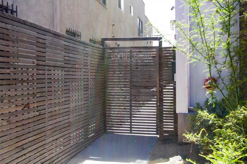 A wooden gate leads residence to units at 611 N Bronson