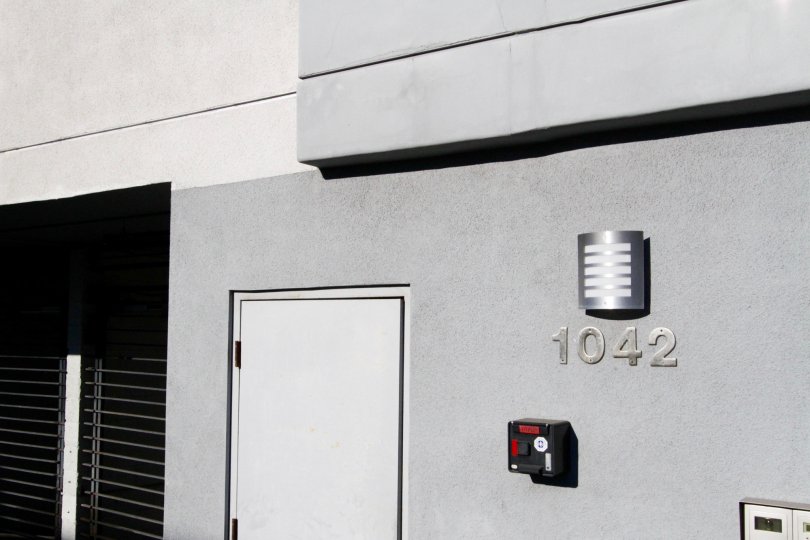 Metal address numbers attached to the stucco side of the Kingsley Manor building