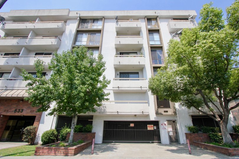 Apartment building in St Andrews Courtyard with personal decks, parking garage, and trees