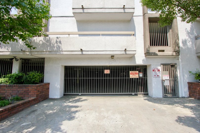 View of closed gated garage entrance of St. Andrews Courtyard with driveway and gated pedestrian door as well.