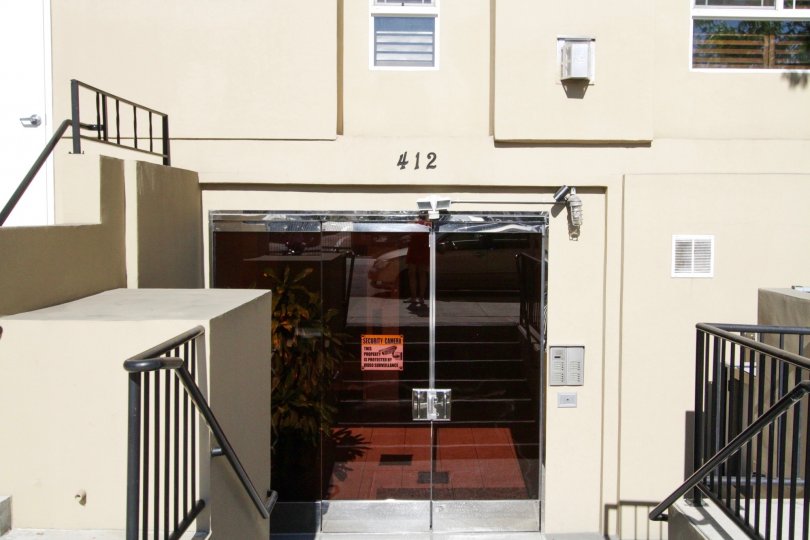 Down a flight of stairs are the glass entry doors to Wilton Villas