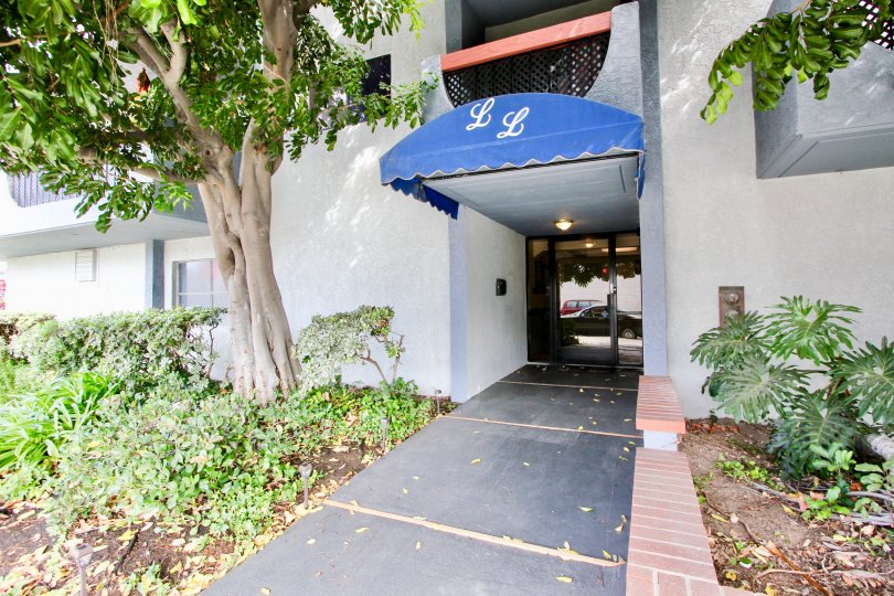 A covered building entrance surrounded by plants in Loma Linda, Long Beach, California