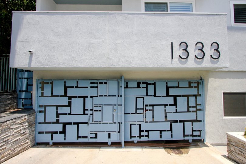 THE GATE WITH SKY BLUE AND BLACK COLOUR AND IT CLOSED THE FIRST FLOOR WITH WINDOWS AT THE MORNING TIME