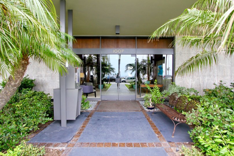 A tiled porch to the Boca Monica community with iron bench on the side.