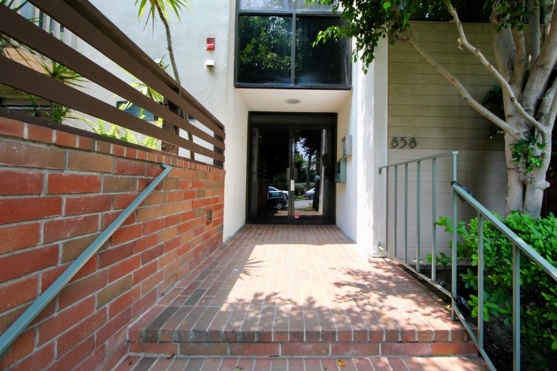 The roof is flat and is covered with red roof tiles. Two large chimneys sit at the side of the house. A few large windows let in just enough light to the rooms below the roof. The house itself is surrounded by a well kept garden. Grass, flower patches and