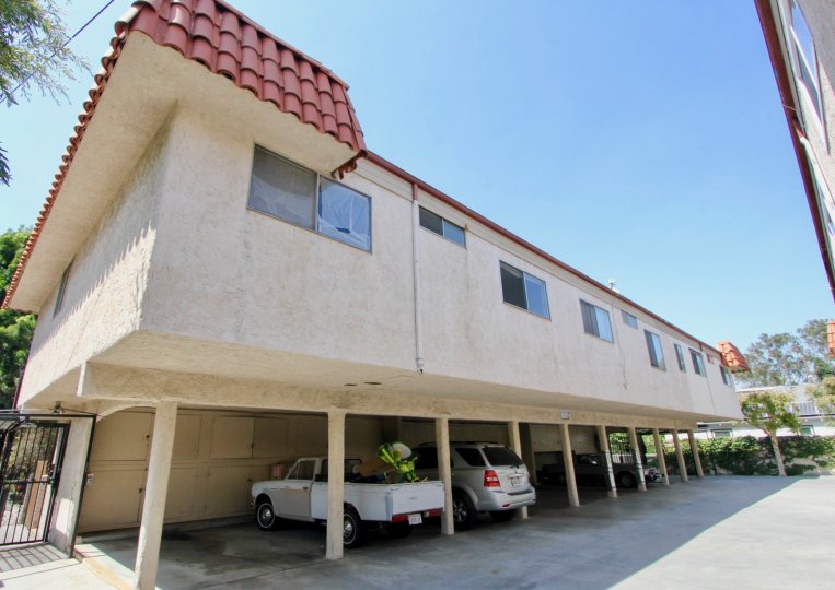 A clear day in the Kansas Ave Condominiums with car parking area.