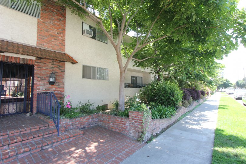 A red brick wall surrounds a garden and apartment building in the 11550 Nebraska community of West LA, California