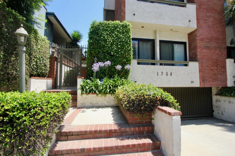 Beautiful planted and cone shaped flower at the staircase entrance of A brick decorated House at Chateau West in in West LA California