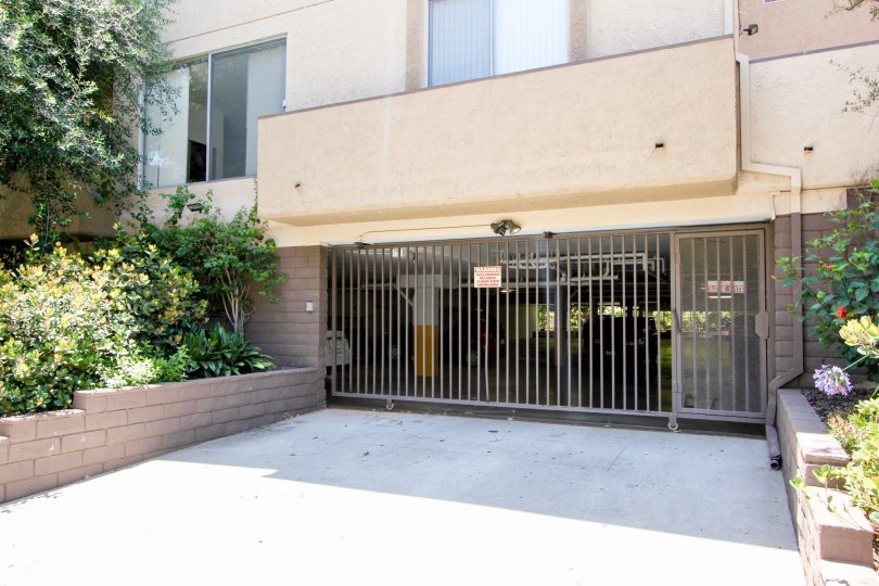 A gated parking garage with shrubbery at The Westwoodian.