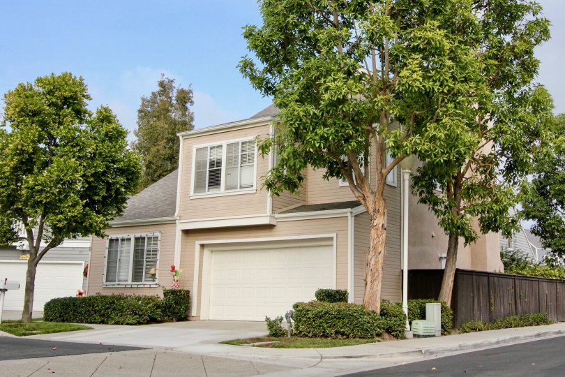 A dusty pink two story home surrounded by trees in the Cape Series community of California.