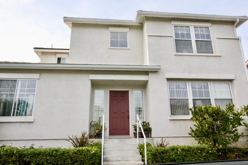 House with a cloudy sky and bushes in the San Simeon Community in Aliso Viejo, CA.