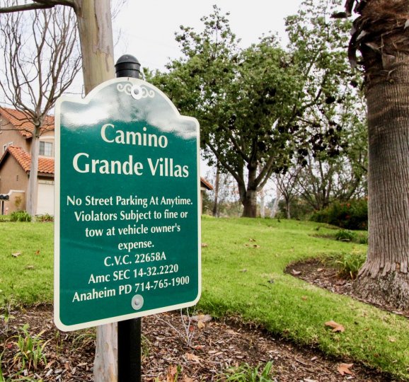 THE HOUSE IN THE CAMINO GRANDE VILLAS WITH THE CAMINO GRANDE VILLAS BOARD, PLANTS, TREES