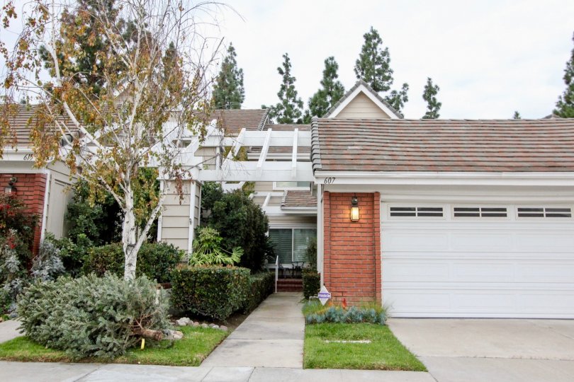 THE FRONT SIDE OF THE HOUSE WITH LAMP, TREES, PLANTS, PATHWAY ARE SHOWN IN THE CITY OF ANAHEIM HILLS