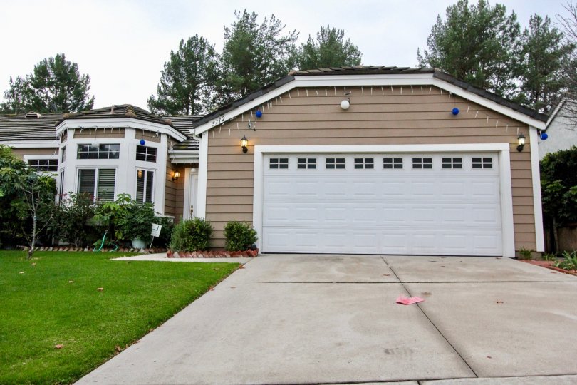 THIS SHOWS THE HOUSE WITH SHED WHICH IS IN CROWN POINTE, THAT HAS BEAUTIFUL LAWN NEARBY MANY PLANTS ARE SHOWN
