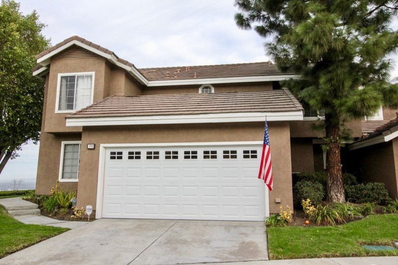 garage front view of the building having flag and decorate with plants in Horizons