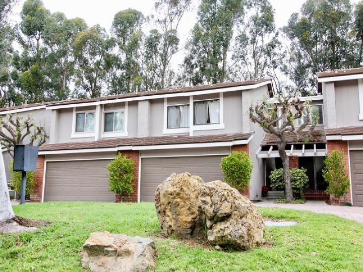 THE VILLAS IN THE PARKVIEW TOWNHOMES WITH THE LAWN, ROCK, PLANTS, TREES