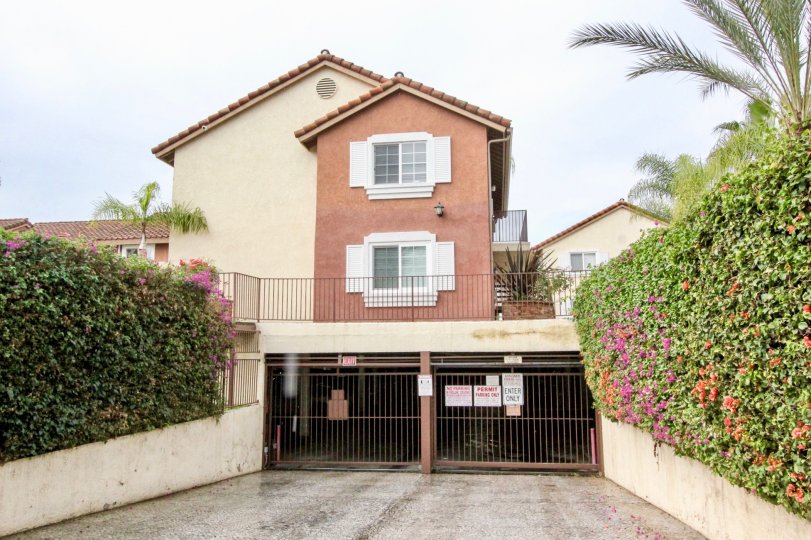 THE FRONT VIEW OF HOUSE IN ANAHEIM WHICH SHOWS THE LONG GATE NAME BOARD PLANTS ON BOTH SIDE