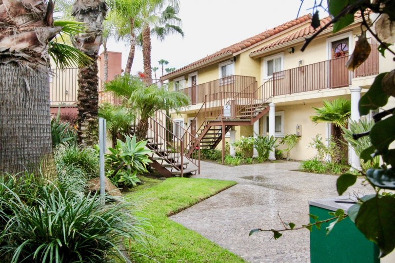 a pleasant day in the Spring Lake Court with a building that has steps in the center garden both side and trees are front