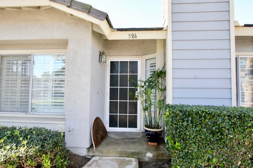 THE FRONT OF THE HOME NUMBER ON THE WALL, FRONT PLANTS, ARE VISIBLE IN THE STANFORD COURT COMMUNITY