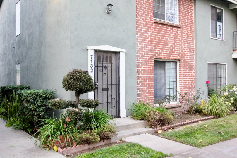 THE 7132 APARTMENT IN THE MONTICELLO TOWNHOMES WITH THE FLOWER PLANTS, LAWN, TREES