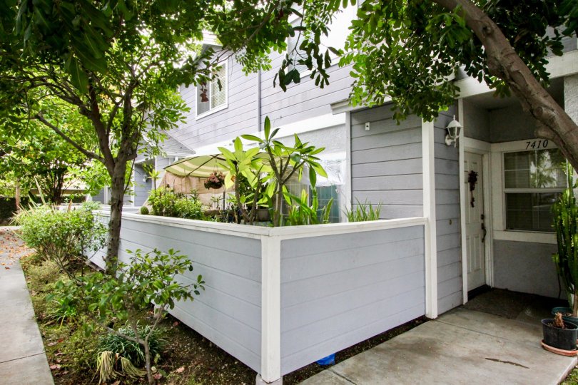 THE FRONT VIEW OF HOUSE WITH NUMBER ON THE WALL WITH LOT OF TREES, PLANTS WHICH IS LOCATED IN BUENA PARK