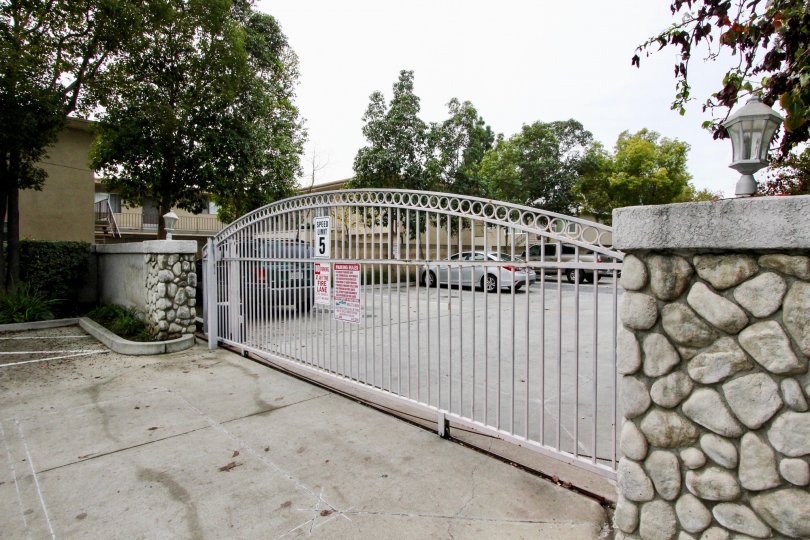 a rainy day in the western bay estates with a building that has parking car and entrance gate closed and stone walls