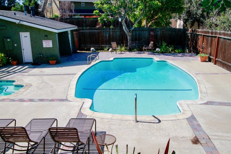 The home in the Back Bay Village Sunrise is like a restaurant with lots of trees, plants and swimming pool with chairs.