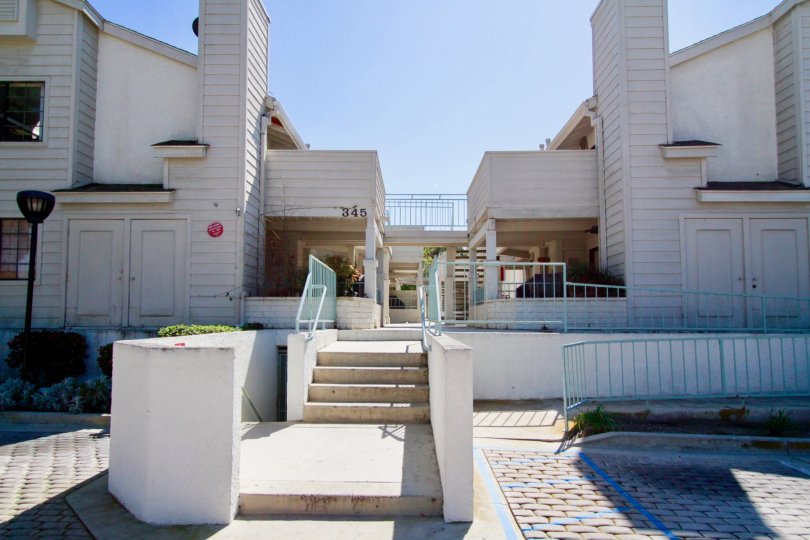 Coral Point apartments with a staircase and street lamp on a sunny day.