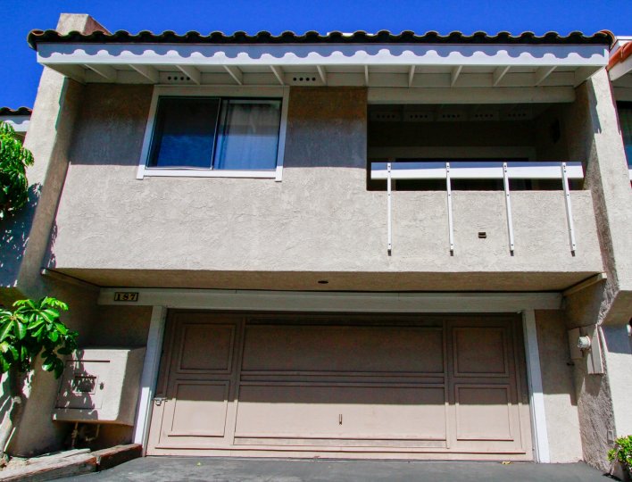 Fairview Village two story building with a garage and balcony on a sunny day.
