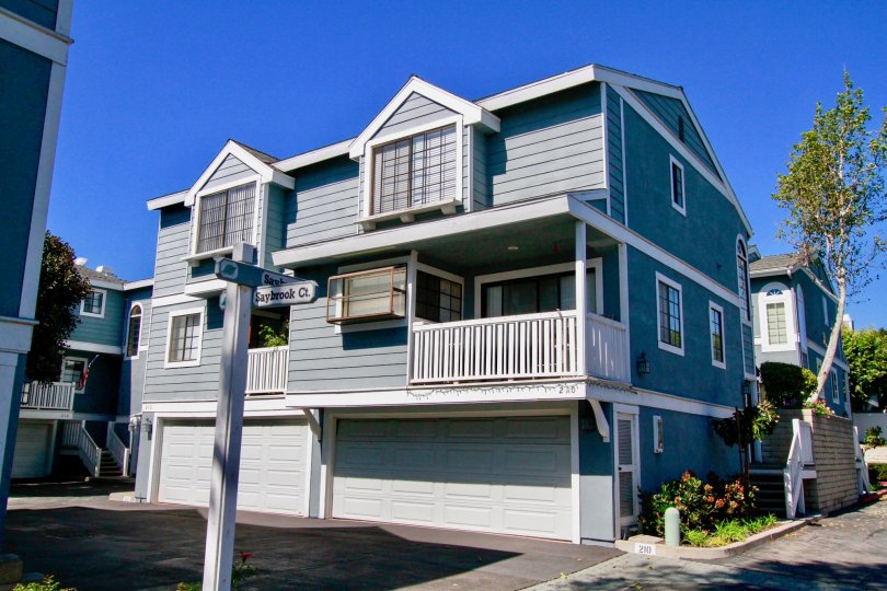 Garden Park Village apartment building with trees and garages on a sunny day.