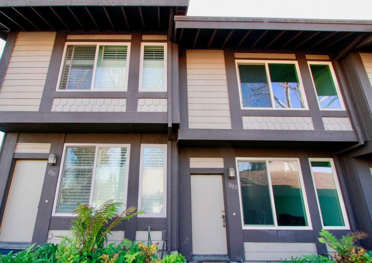 Mesa Bluffs two story building with ferns on a sunny day.