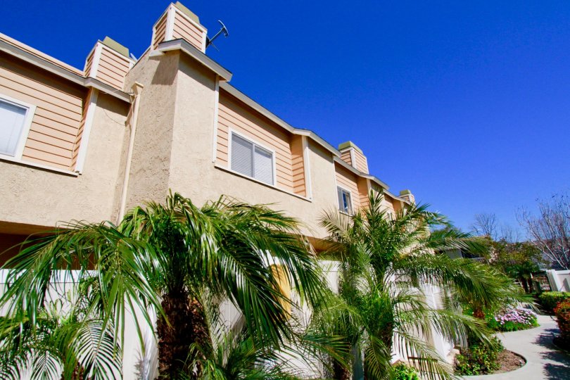 Ocean Breeze Villas apartments with a fence and palm trees.
