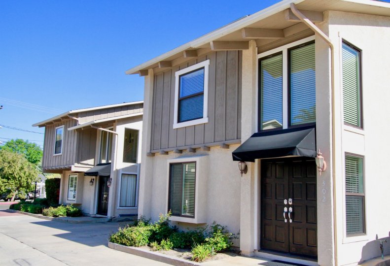 Peppertree Heights two story apartments with brown doors on a sunny day.