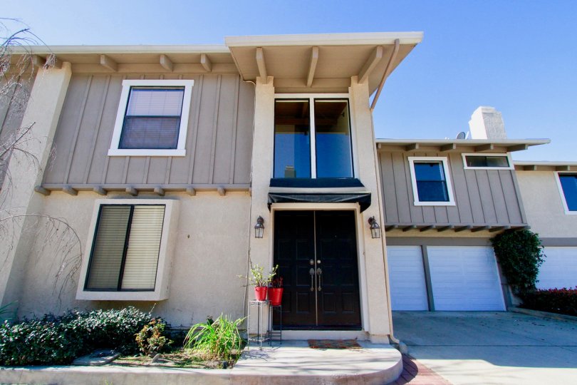 Peppertree Heights two story apartments with garages brown doors on a sunny day.