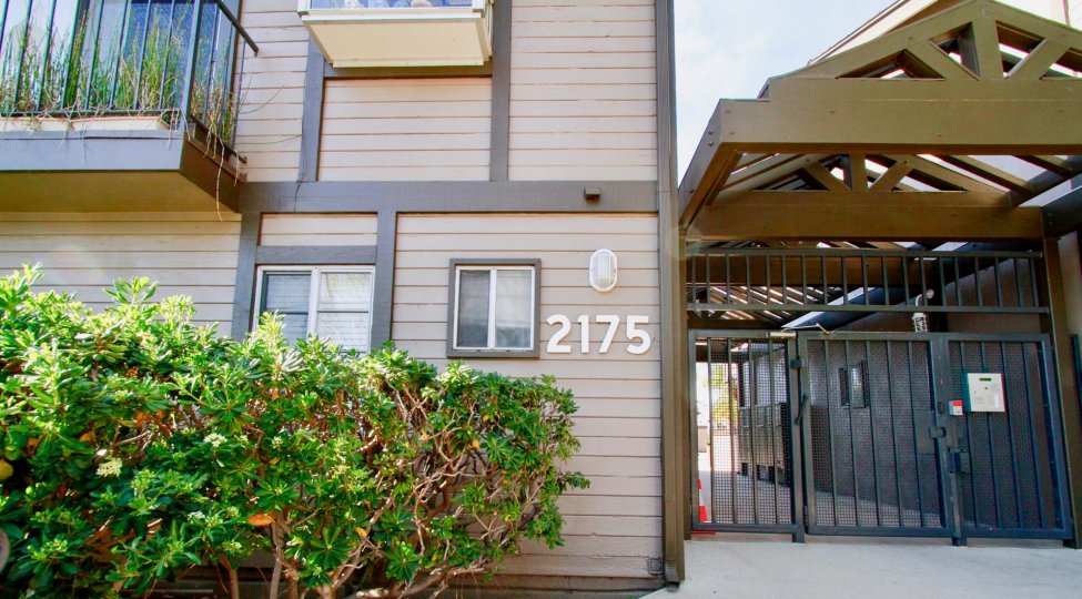 Sea Ridge community gate and street number with bushes on a sunny day.