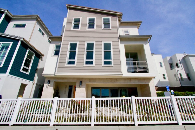 Seabreeze apartments with a white fence on a sunny day.