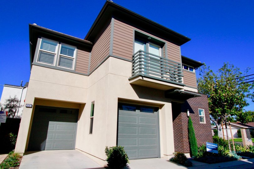 Two story The Edge apartment with a garage and balcony on a sunny day.