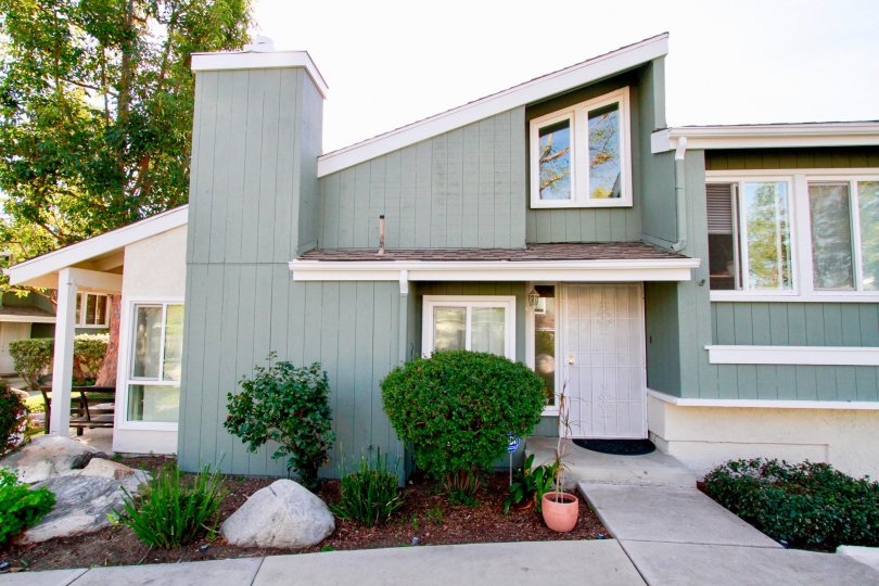 a trendy grey modern house which has the garden in front of that is located in village creek of costa mesa, california
